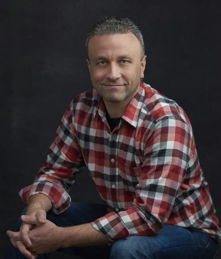 Jason Resnick, seated, in a red plaid shirt